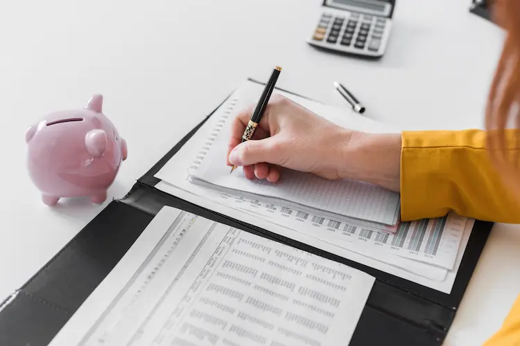 Agência marketing digital orçamentos reduzidos: mulher a analisar ficha e a fazer contas para otimizar custos e métricas.